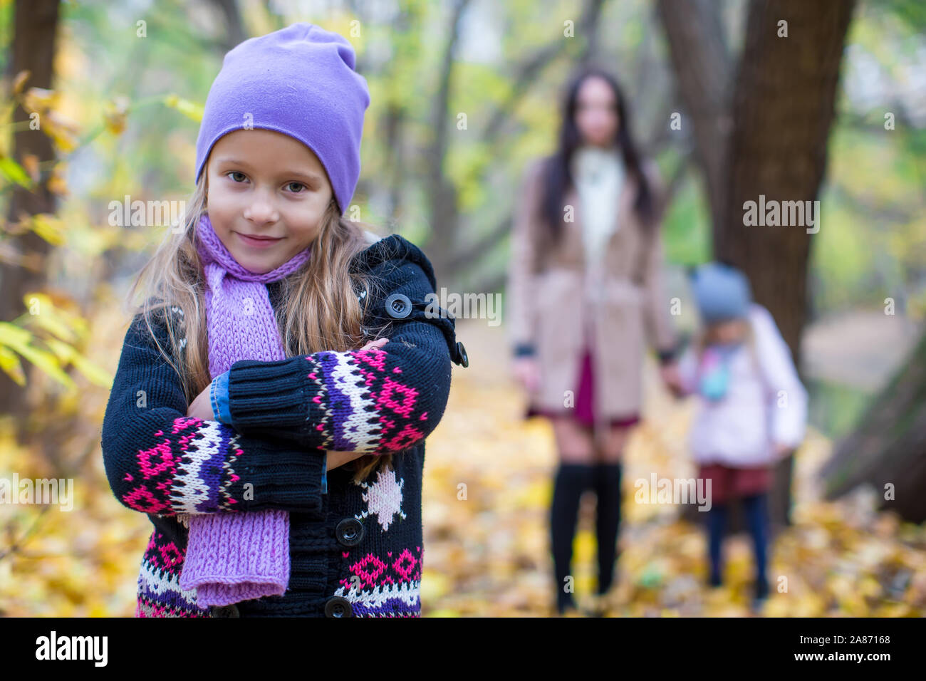 Little girls and young mother in autumn park on sunny warm day Stock ...