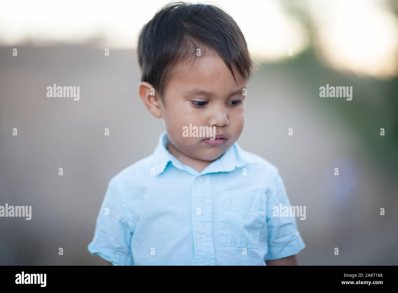 A little boy whose look is characterized by the examination of his own thoughts and feelings, withdrawn and unaware of the external world. Stock Photo