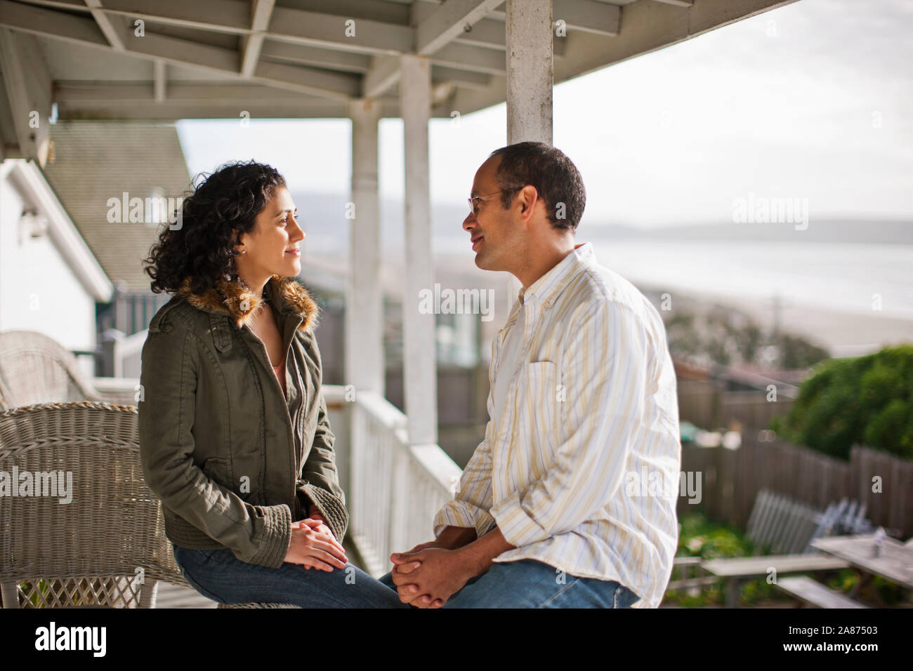 Happy young couple talking on a verandah. Stock Photo