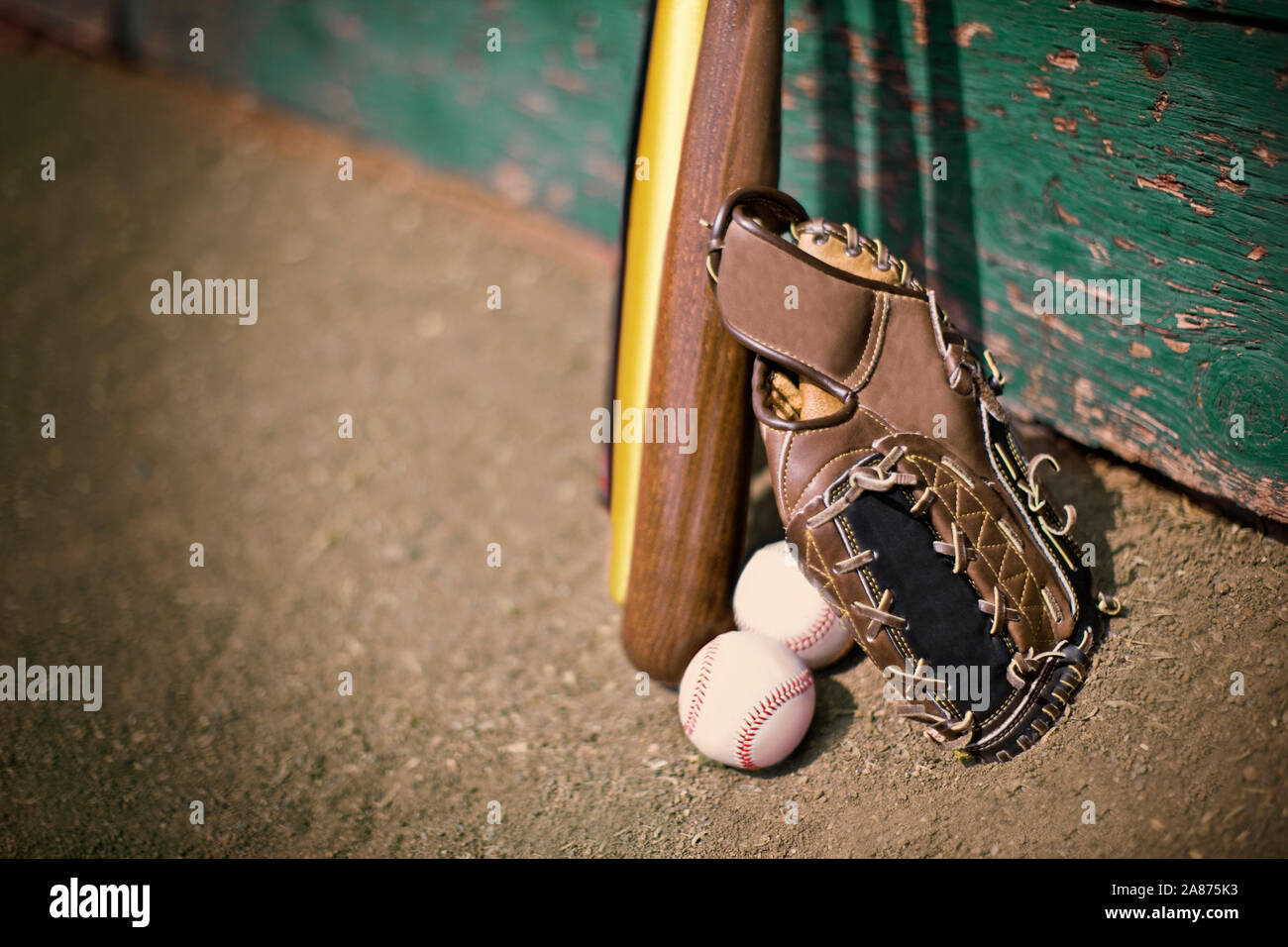 Leather baseball mitt next to baseball bats and balls Stock Photo Alamy