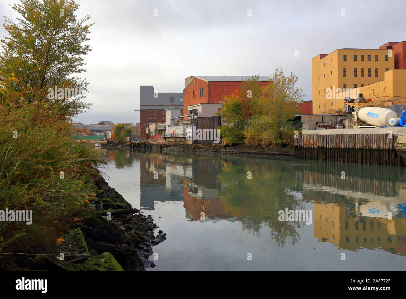 A view of the Gowanus Canal looking west toward Smith St. After a recent rainstorm and surface water runoff, there is a visible oil slick in the water Stock Photo
