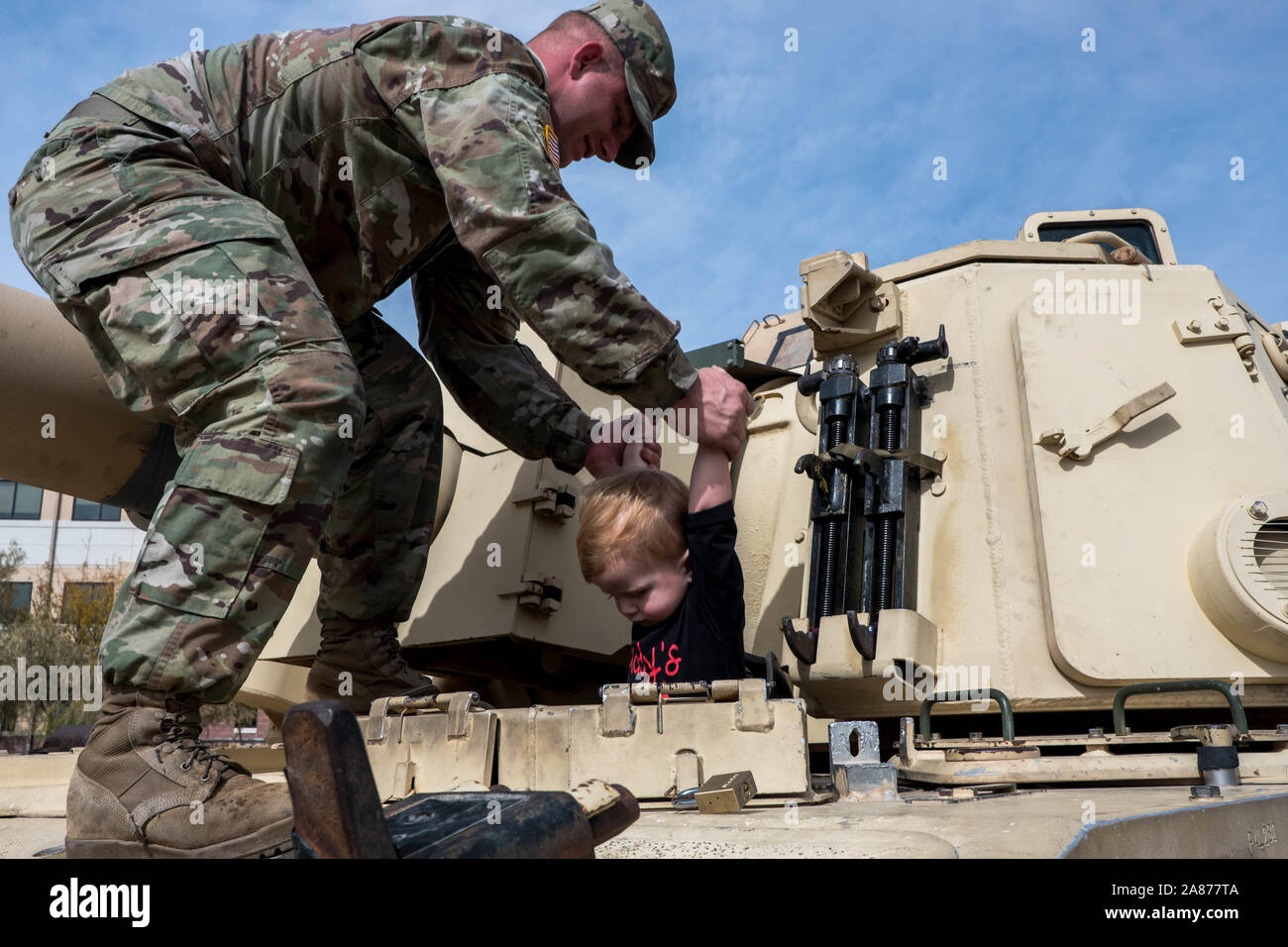 El Paso, Texas, USA. 6th Nov, 2019. SPC. CORY RITCH, left, of the 3rd Armored Brigade Combat Team, 1st Armored Division, lifts his son GABRIEL, 2, right, from the driver's seat of a tank on display during the celebration of Torch Week at Fort Bliss in El Paso, Texas. The celebration commemorates the United States' invasion of North Africa during Operation Torch on November 8 through November 16, 1942 during World War II. Credit: Joel Angel Juarez/ZUMA Wire/Alamy Live News Stock Photo