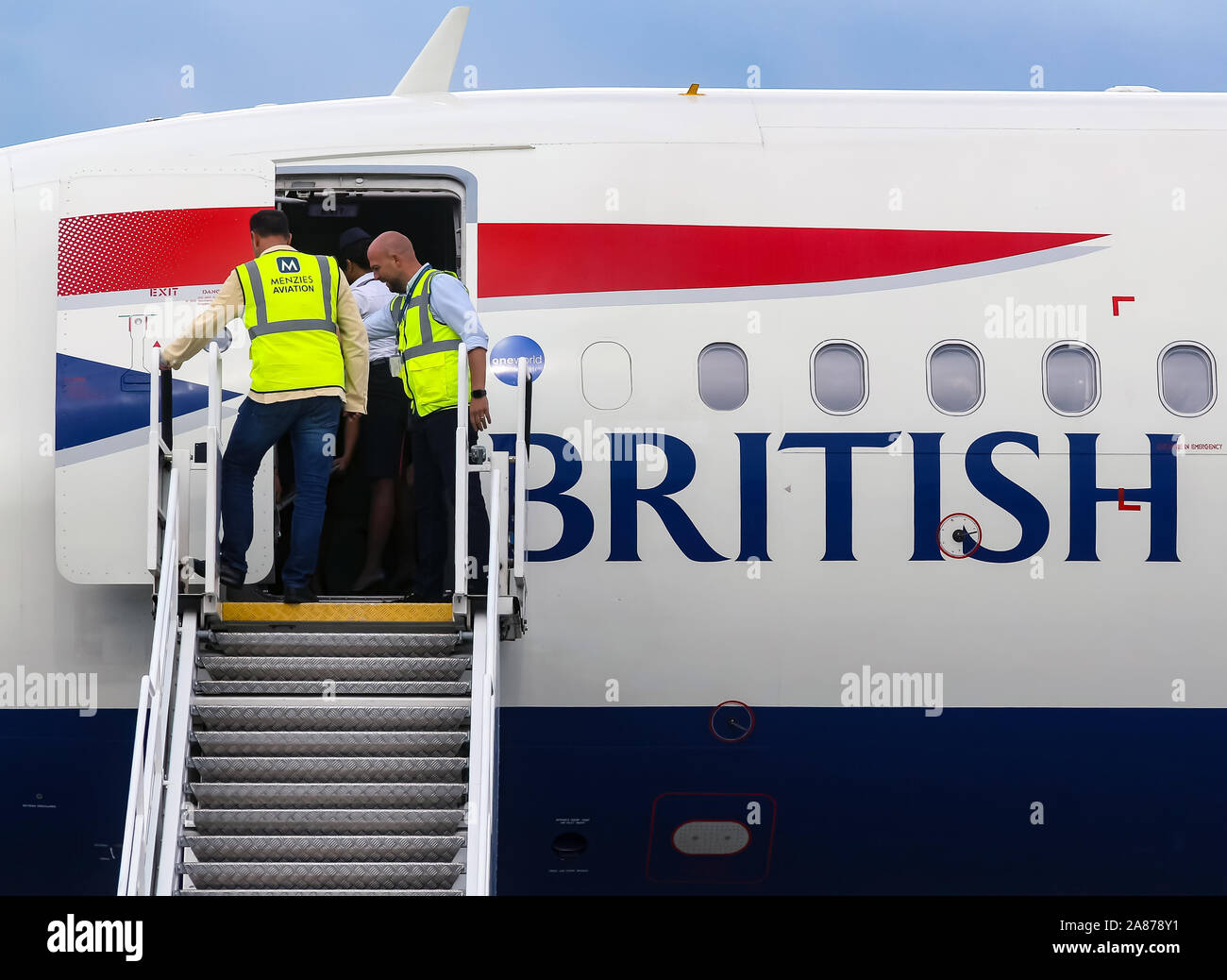 Bucharest, Romania - July 15, 2019: Ramp agents secures the ladder of British Airways G-EUXG aircraft parked in the VIP reception area of Henri Coan Stock Photo