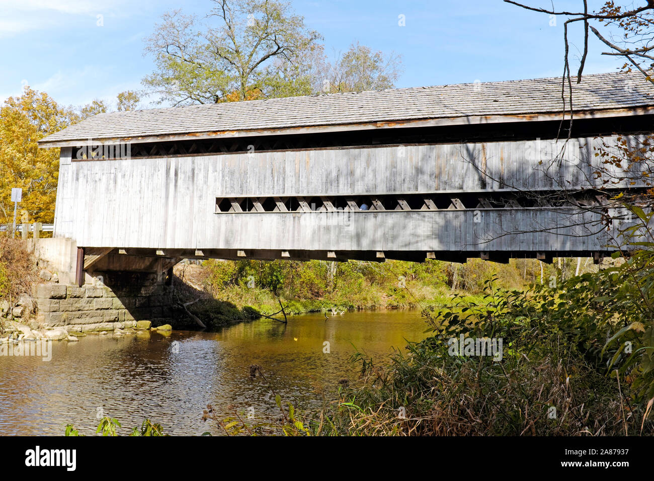 The wooden covered drivable Doyle Road Bridge over Mill Creek in Jefferson Township, Ashtabula County, Ohio is a single span Town truss design. Stock Photo
