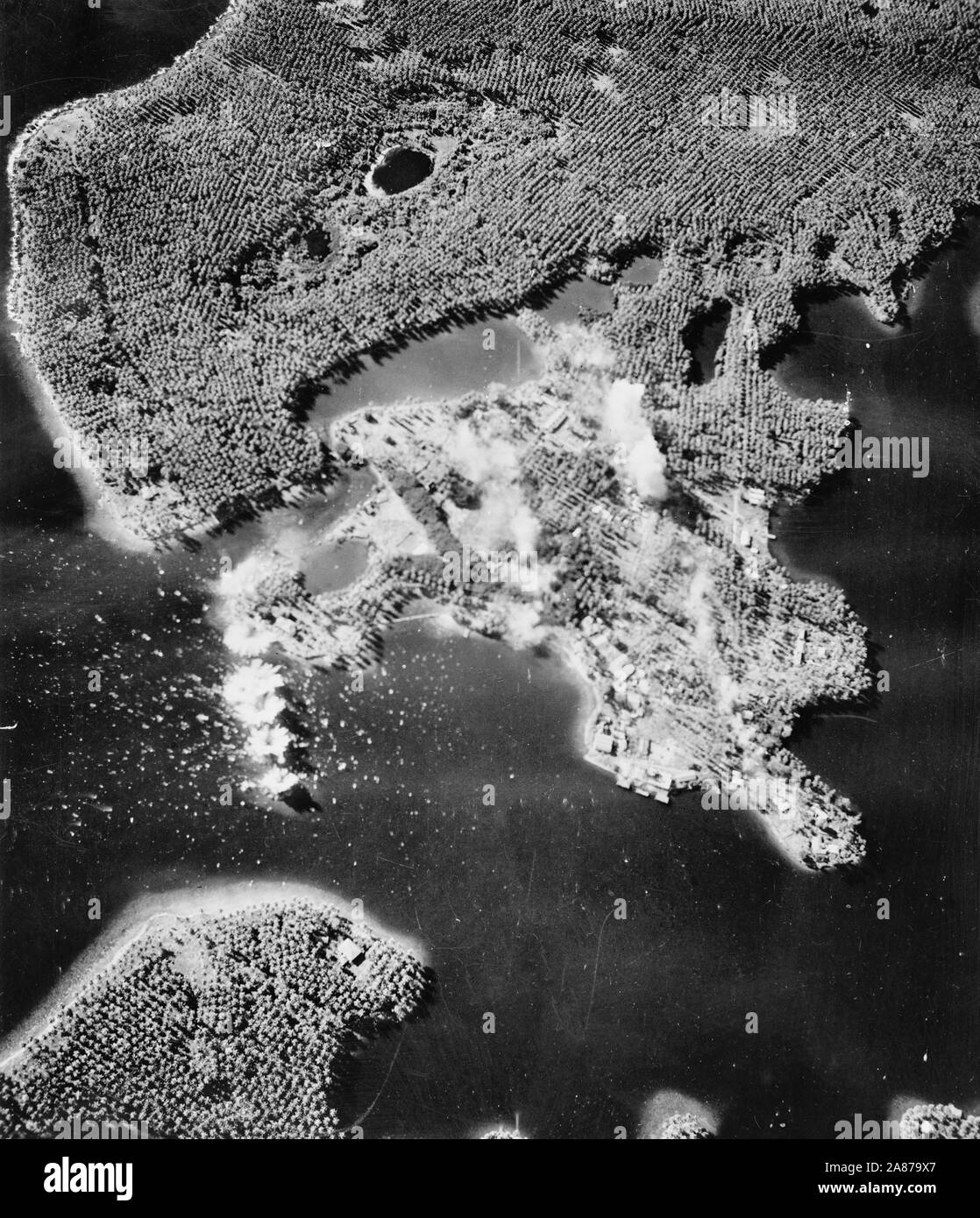 A train of six bombs from United States Army Air forces planes drops on the base of Mandang on the north coast of New Guinea held by the Japanese. During this raid more than thirty-eight tons of bombs were dropped on the airdrome and other vital objectives. 1943 Stock Photo