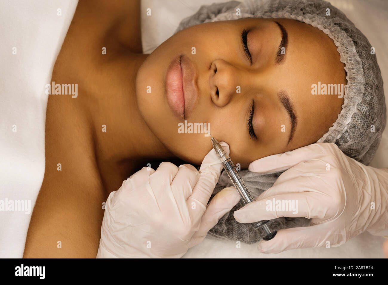 Injection cosmetology: contour plastic. Doctor makes rejuvenating facial injections procedure. Filling nasolabial fold with preparation with hyaluroni Stock Photo