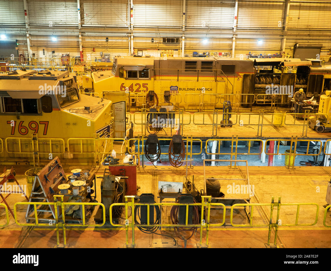 Two train engines in a factory undergoing repair Stock Photo