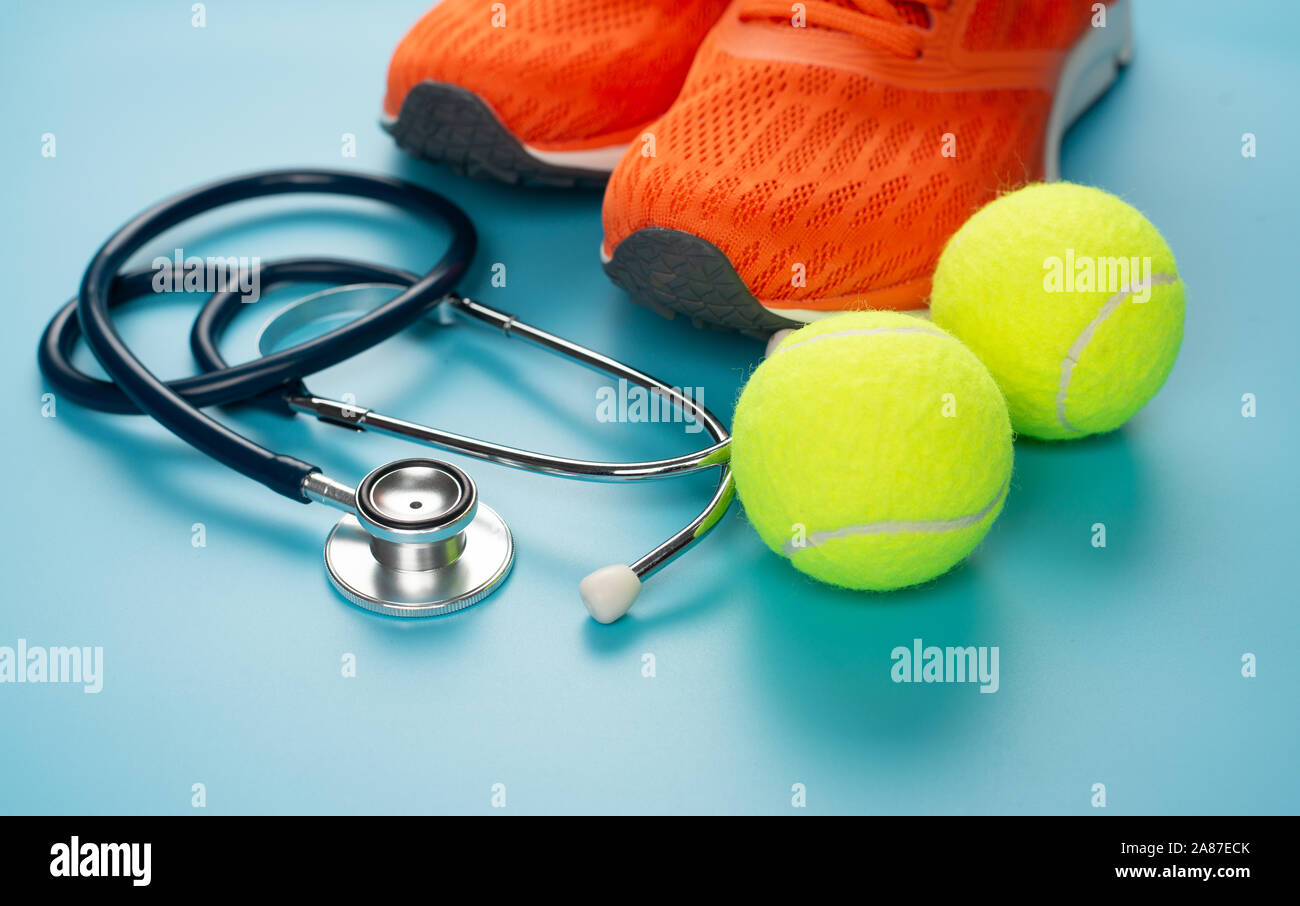 Orange sports shoes and stethoscope on the blue background. Concept exercise for good health