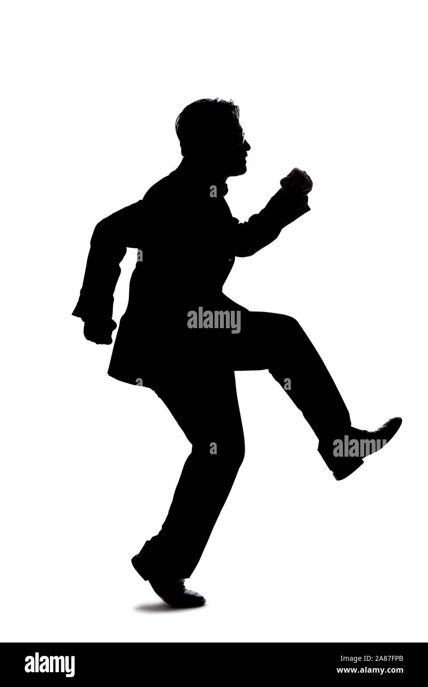 Silhouette of a backlit model posing as a businessman on a white