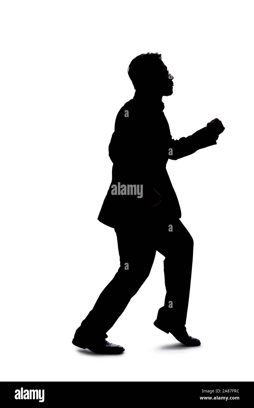 Silhouette of a backlit model posing as a businessman on a white