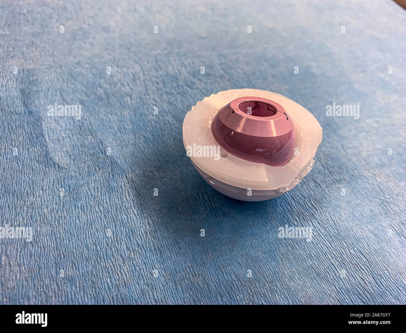 a duo head hip prosthesis is placed on a light blue cloth, with the cup