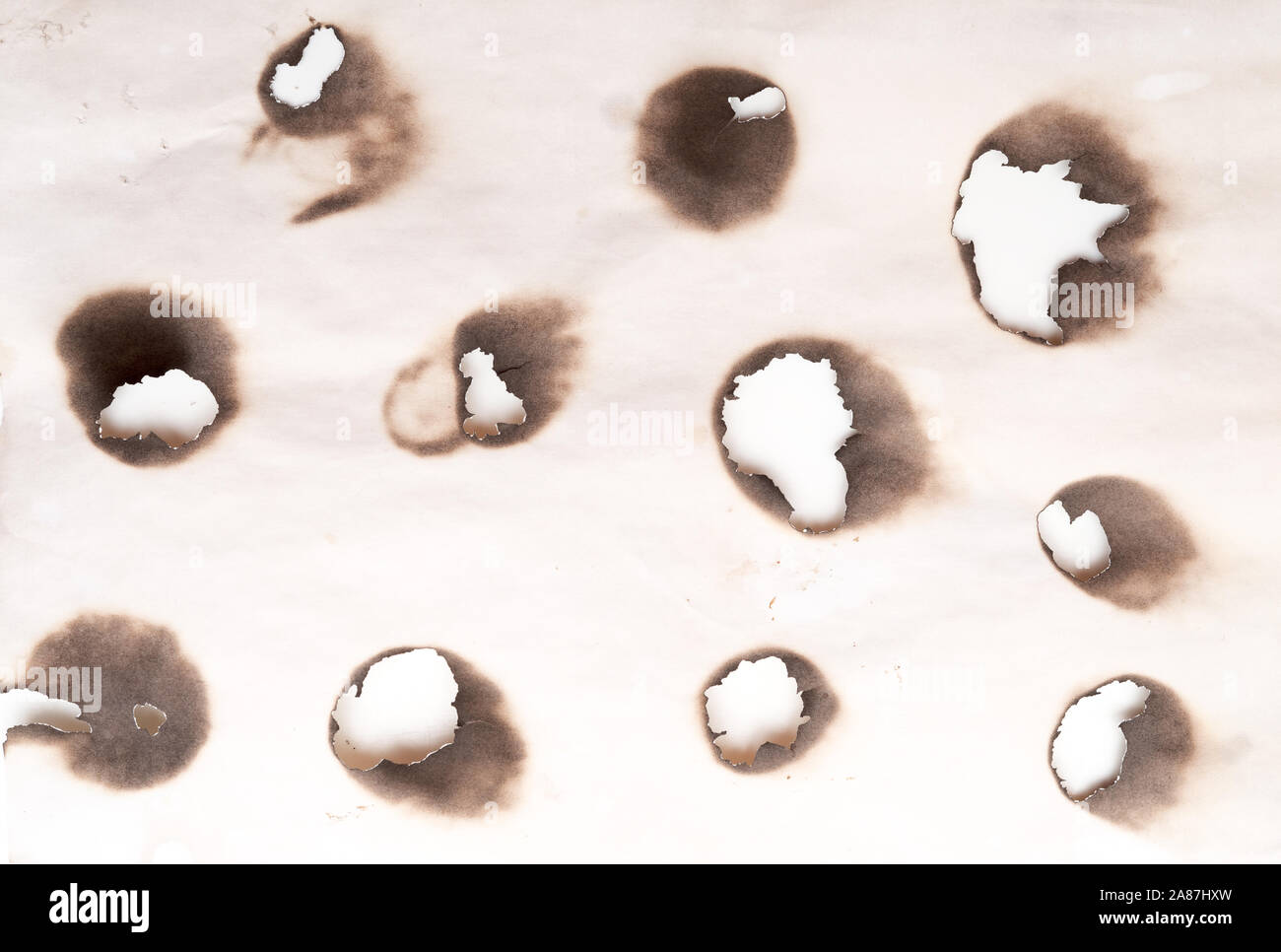 Burnt holes in a paper Stock Photo Alamy