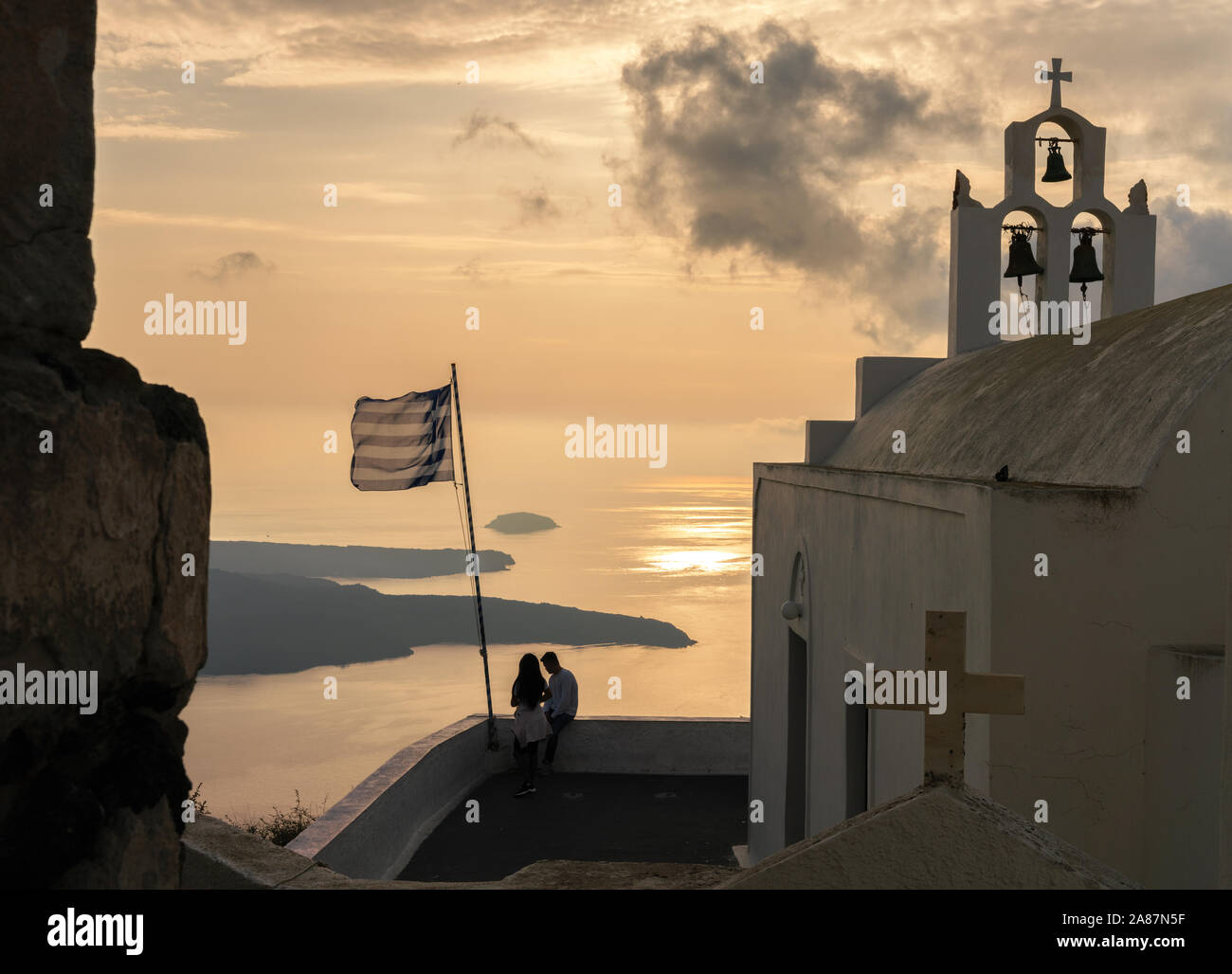 31th Oct 2019 - Santorini, Greece. A couple enjoy a picturesque sunset views of the Agean sea and capital town of Fira. Stock Photo