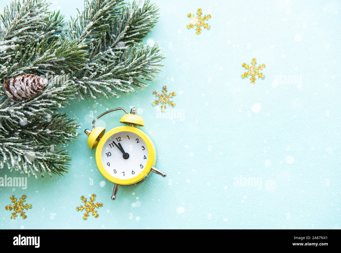 Alarm clock with fir tree branches and copy space on blue background ...