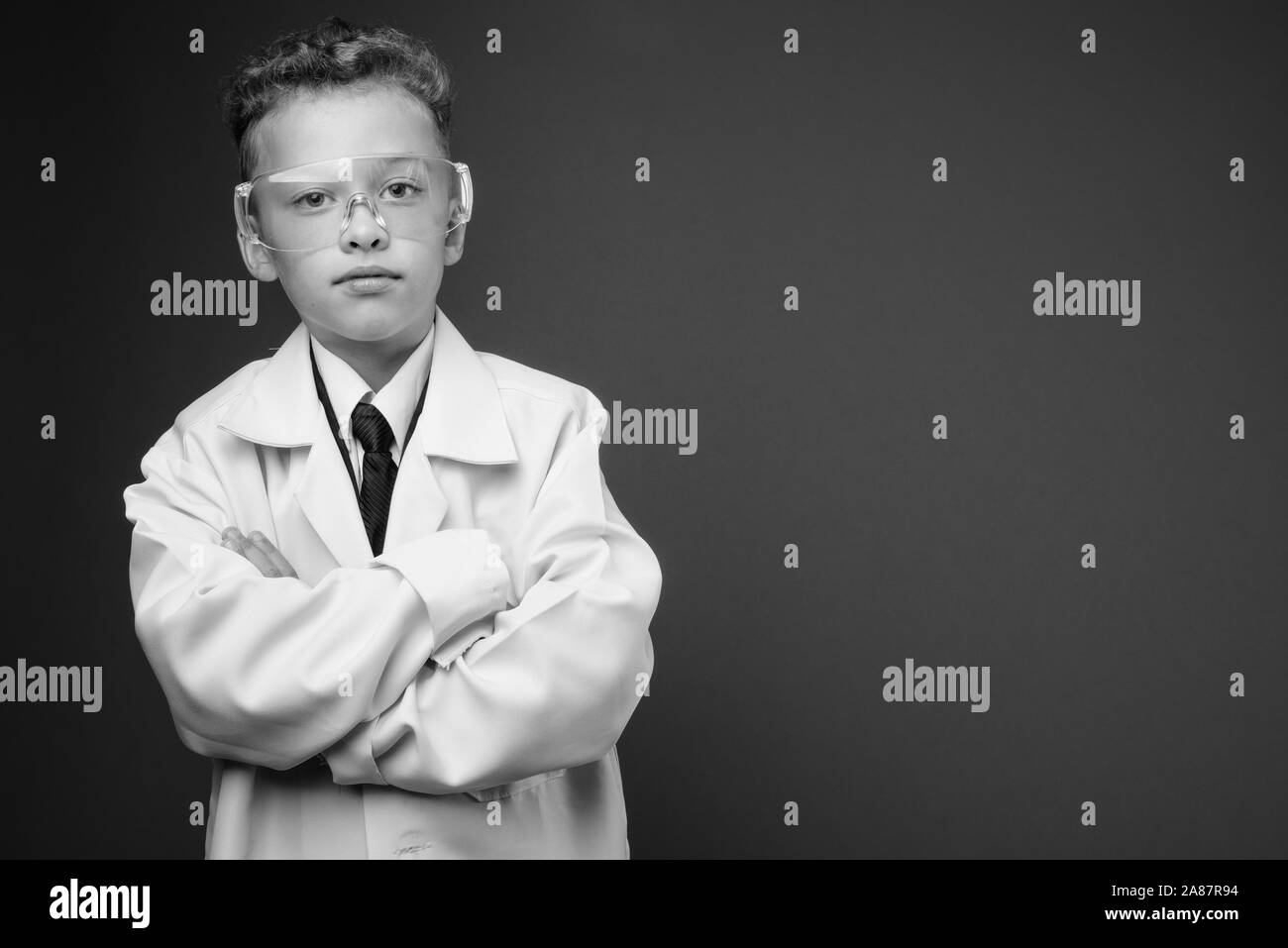 Young boy as doctor wearing protective glasses in black and white Stock Photo