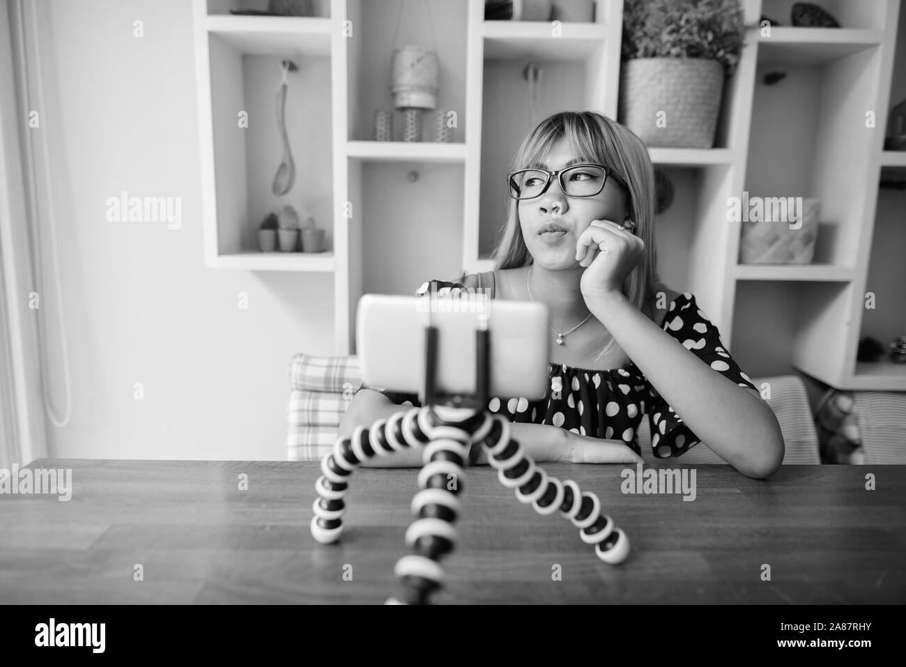 Young Asian teenage girl vlogging with phone at home Stock Photo