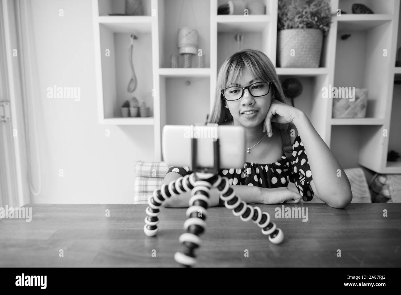 Young Asian teenage girl vlogging with phone at home Stock Photo