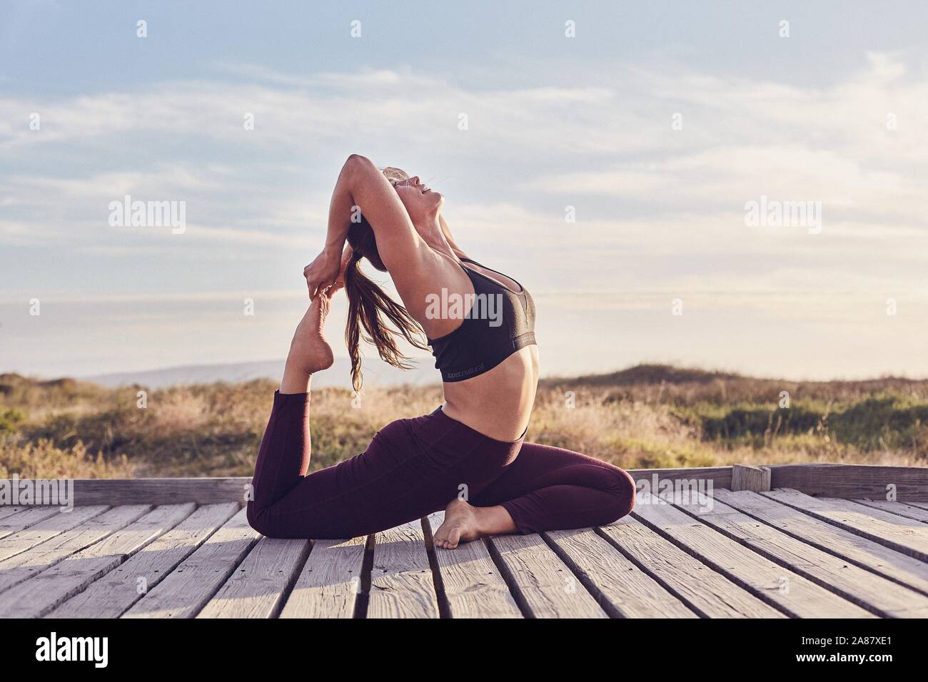 Young woman on beach stretching hi-res stock photography and images - Alamy