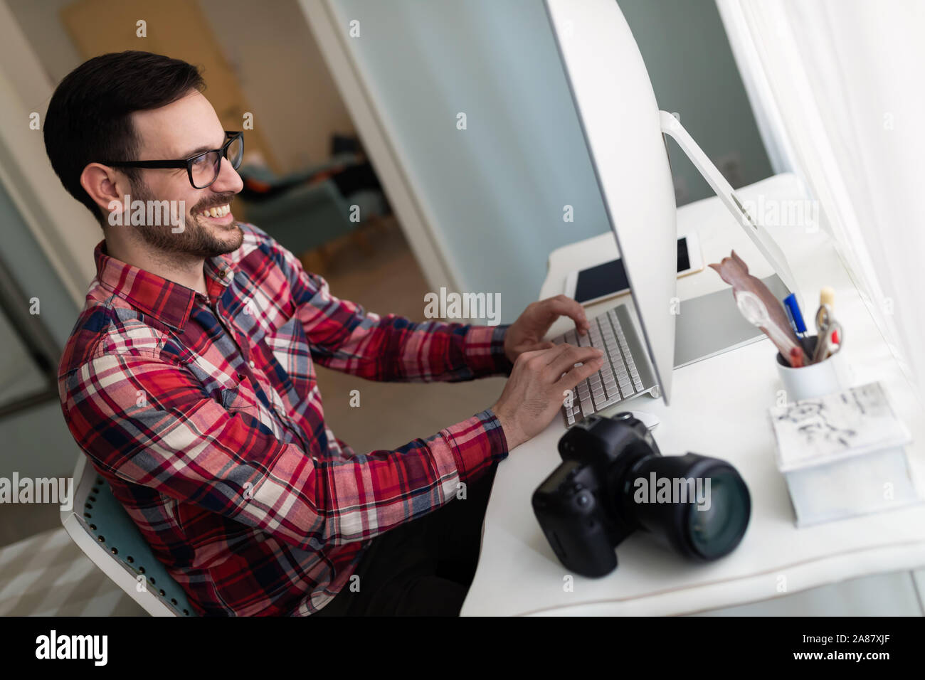 Young handsome designer working on project on computer Stock Photo