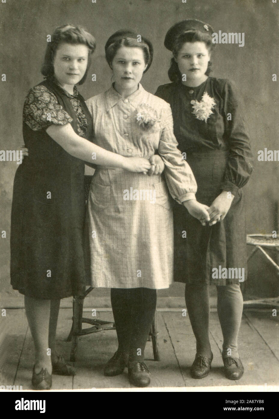 1946 year. Three Russian girls posing in the photo pavilion. Dressed in fashionable dresses, in berets. Rostov region Kamensk-Shakhtinsky. THE USSR. Stock Photo