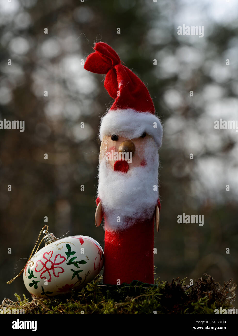 A hand made santa claus figure with cotton beard and a christmas ball