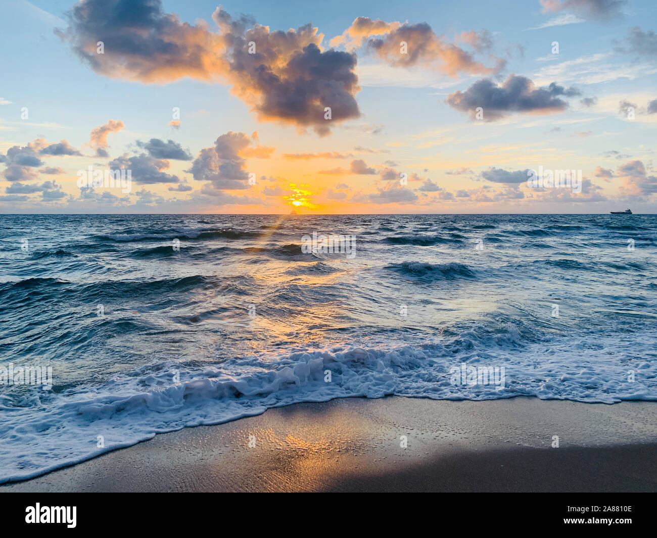 orange sun rising out of the blue ocean in Florida Stock Photo - Alamy