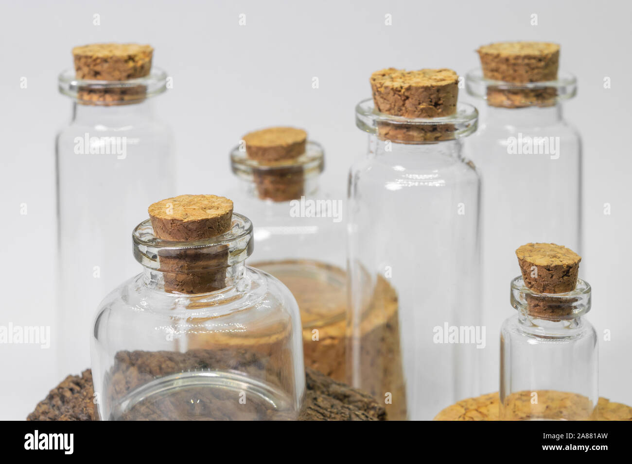 Various glass bottles with cork lids in white background and placed on