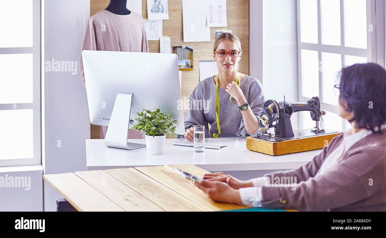 pretty dressmaker showing a new design to her client Stock Photo - Alamy