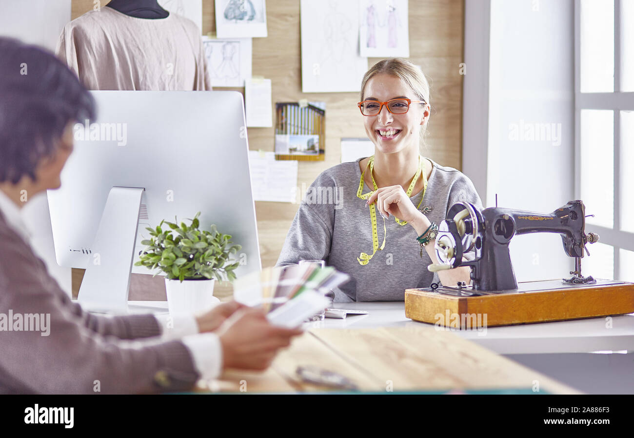 pretty dressmaker showing a new design to her client Stock Photo - Alamy