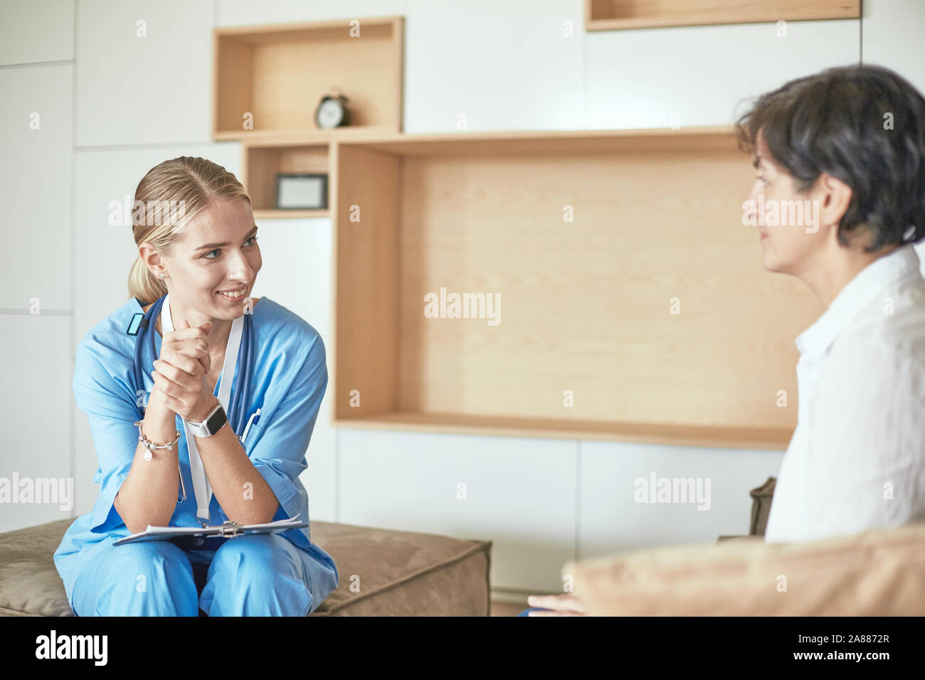 Friendly Smiling Doctor And Patient Sitting On The Couch Very