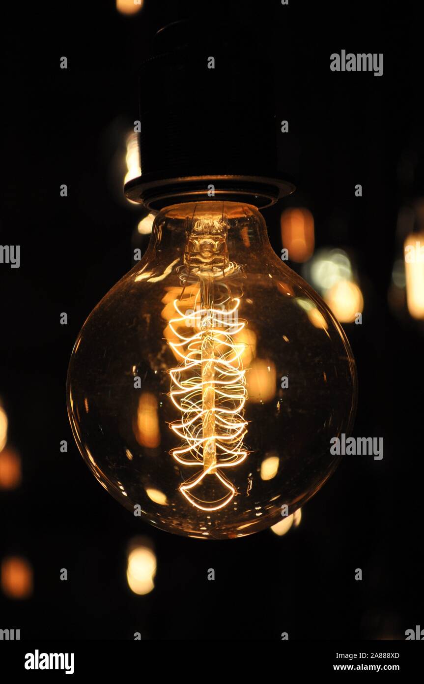 Close-up photo of a switched on designer decorative light bulb showing the filament details Stock Photo