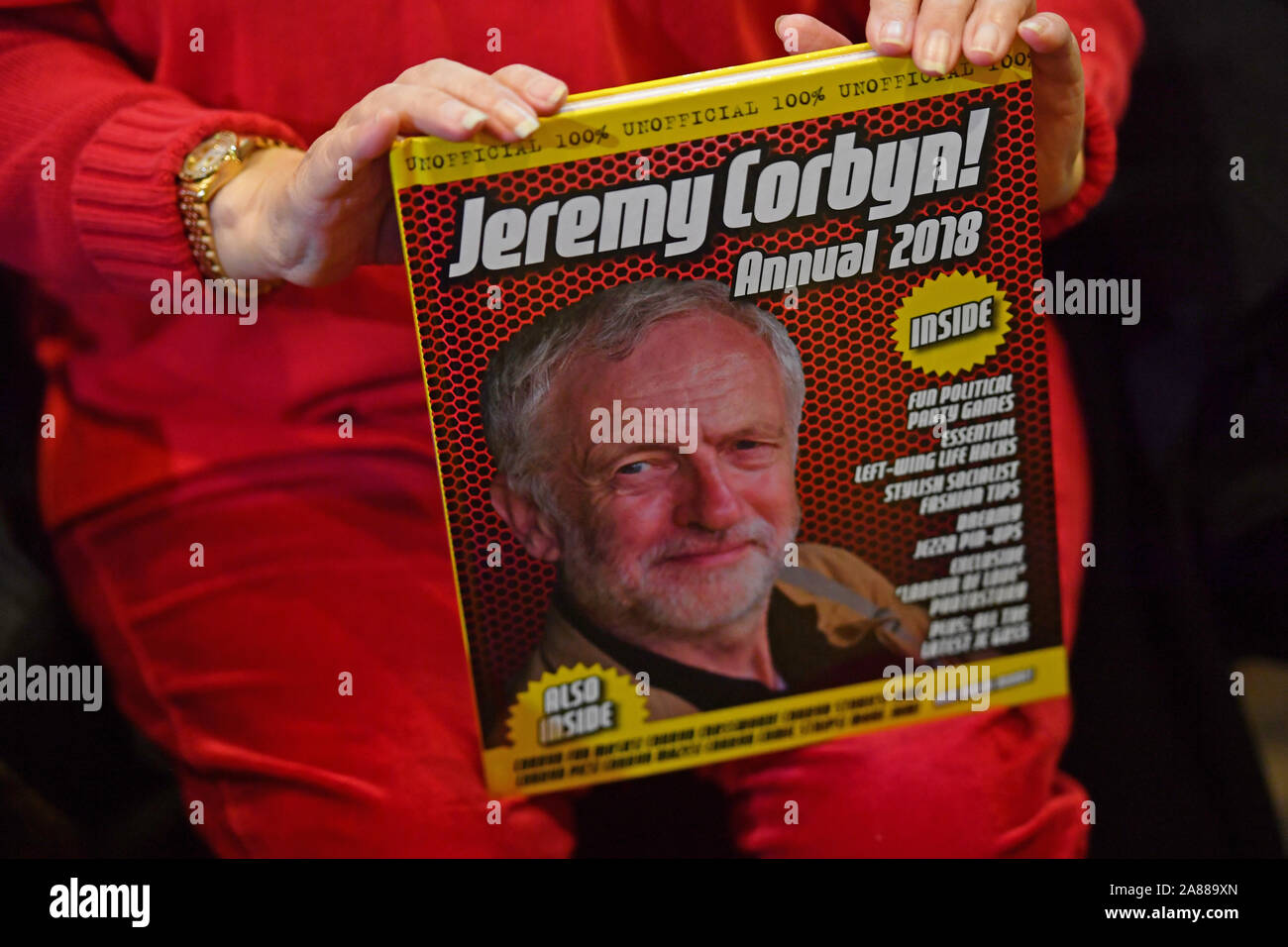 A Labour supporter holds a Jeremy Corbyn annual as she awaits a speech from Shadow Chancellor John McDonnell in Liverpool. Stock Photo