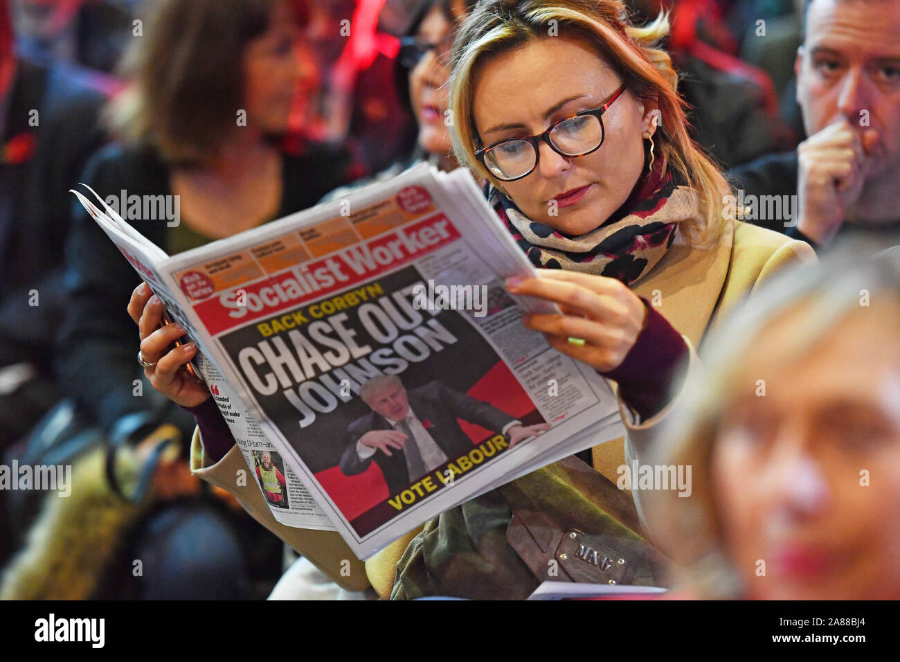 A Labour supporter reads a copy of the Socialist Worker as she awaits a speech from Shadow Chancellor John McDonnell in Liverpool. Stock Photo