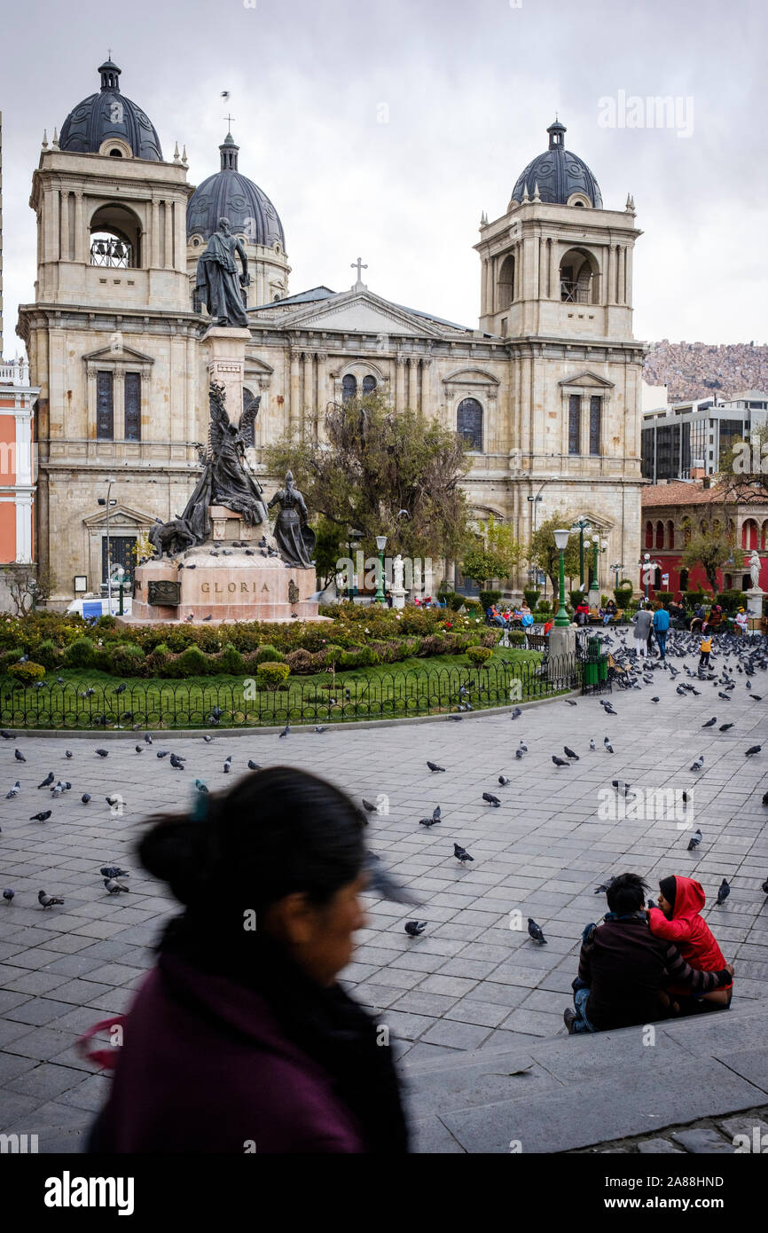 Couple sitting on Plaza Murillo in the Historic District with the Cathedral of Our Lady of Peace in the background, La Paz, Bolivia Stock Photo