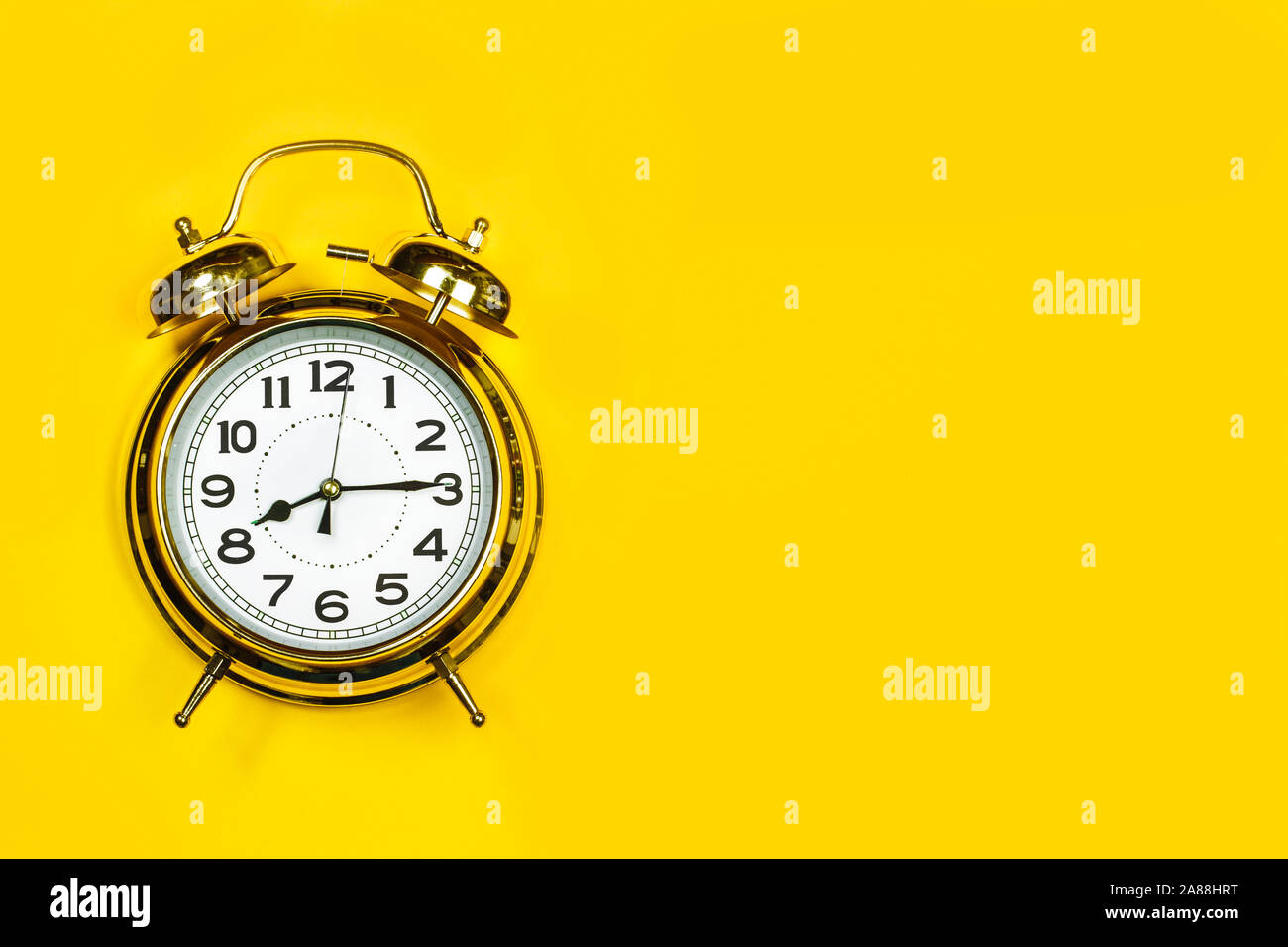 Old alarm clock on a yellow background Stock Photo - Alamy