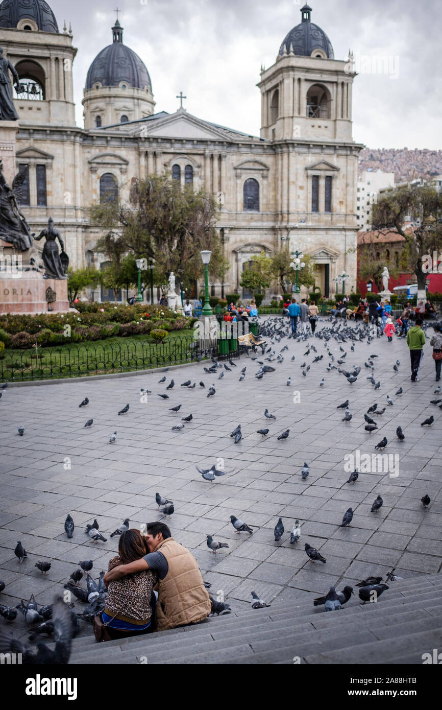 Couple kissing on Plaza Murillo in the Historic District with the Cathedral of Our Lady of Peace in the background, La Paz, Bolivia Stock Photo