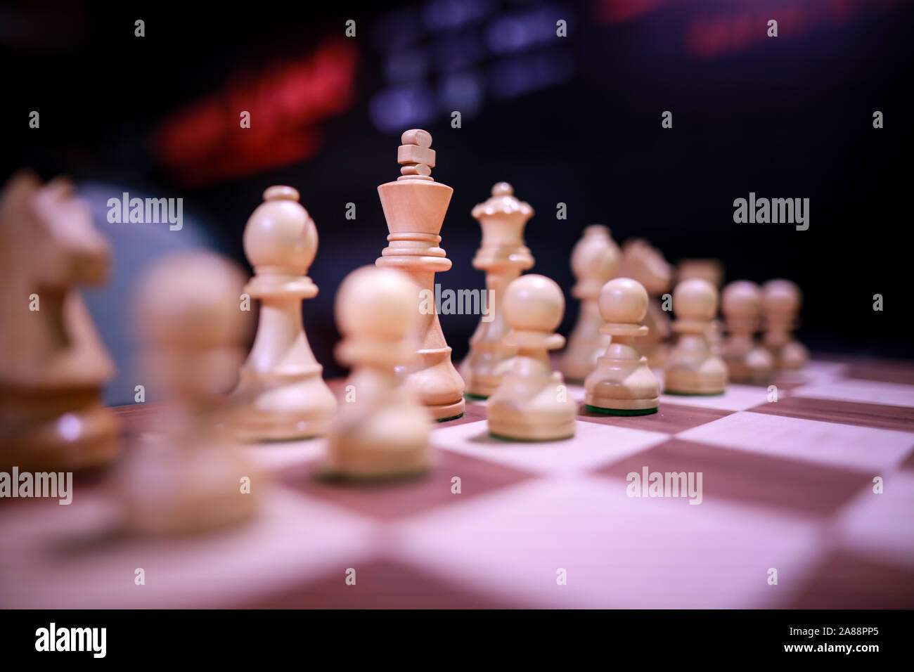 Shallow depth of field (selective focus) image with wooden chess pieces on a wooden table before a professional competition. Stock Photo
