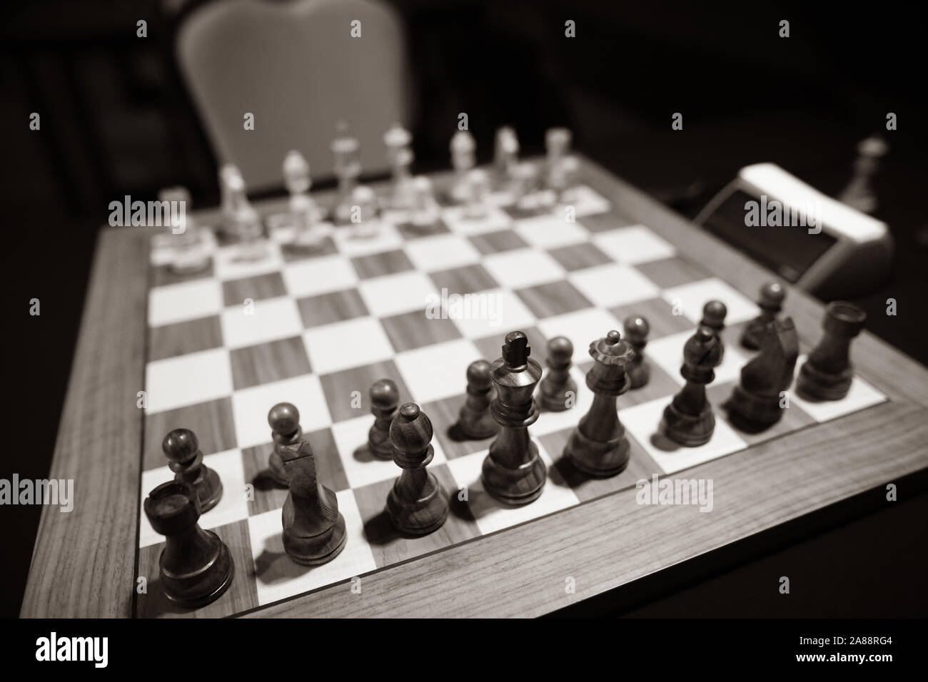 Monochrome shallow depth of field (selective focus) image with wooden chess pieces on a wooden table before a professional competition. Stock Photo