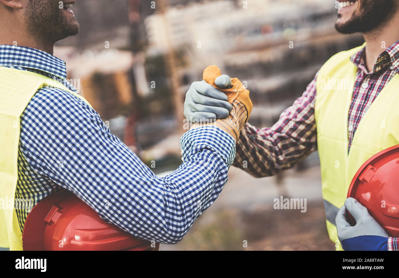 Young builders shaking hands making an agreement on construction site