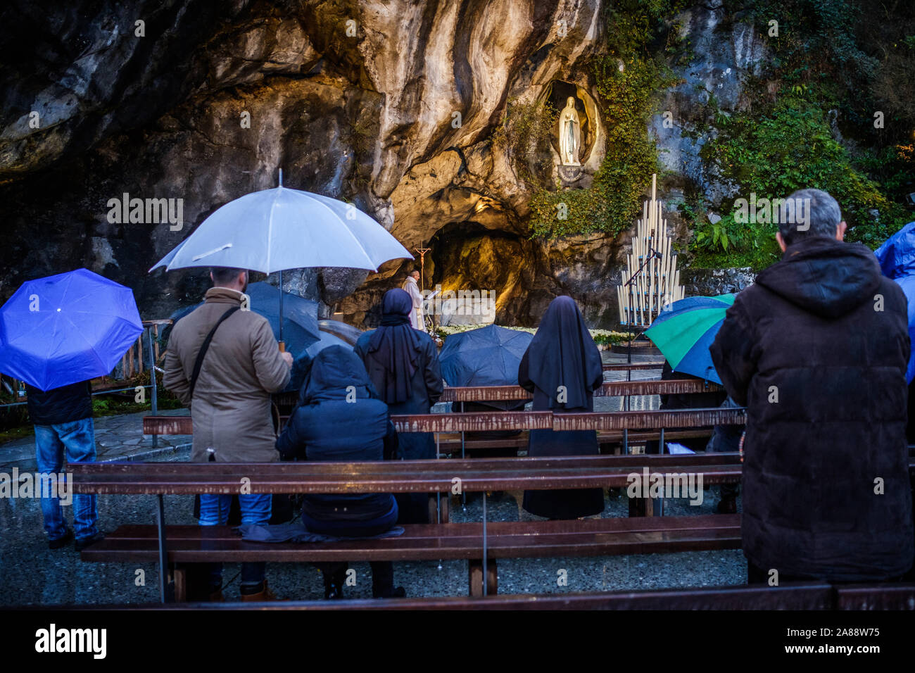 Lourdes (southwestern France). Pilgrims praying under the rain at the