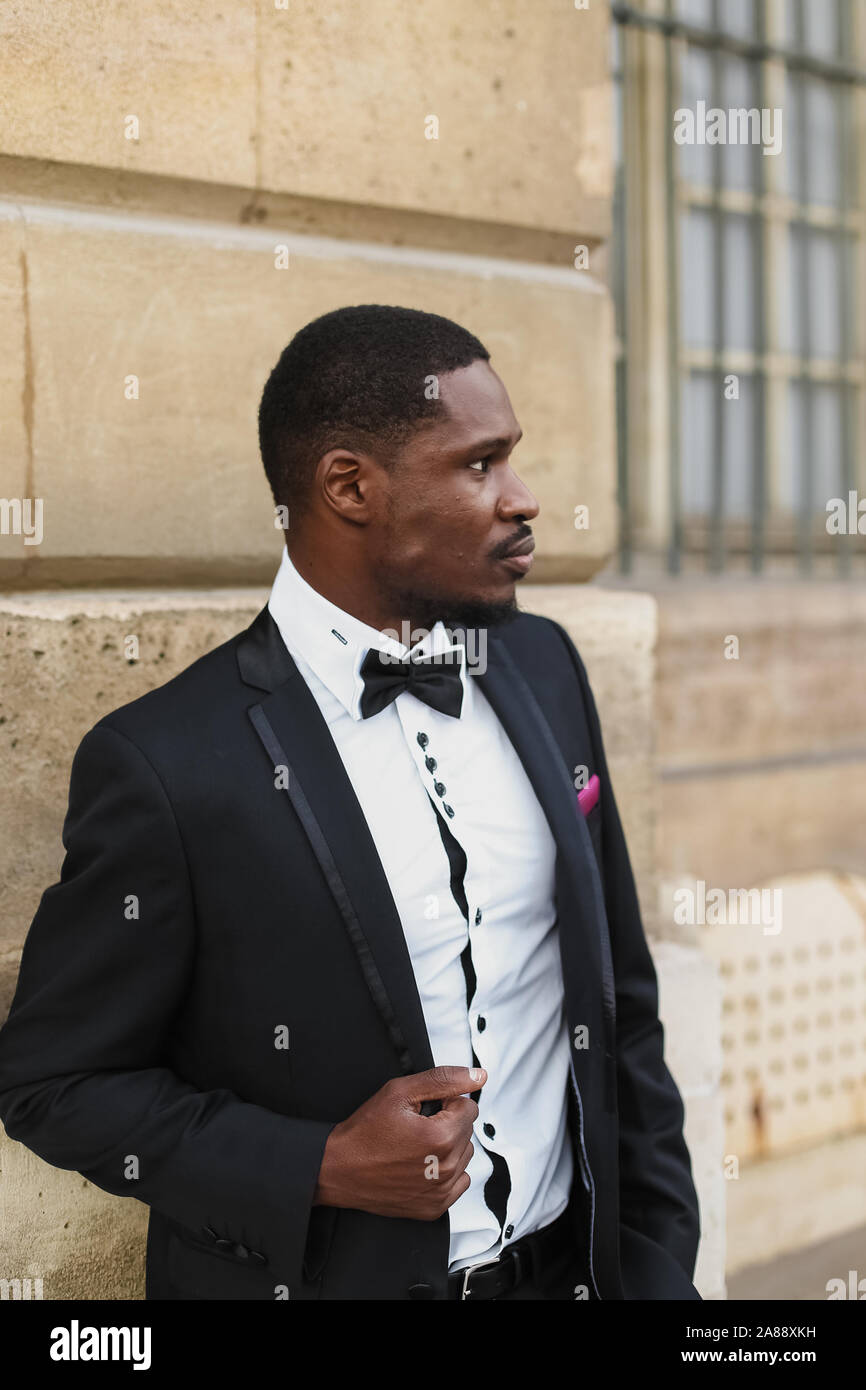 Afro american man wearing suit and standing near building Stock Photo ...