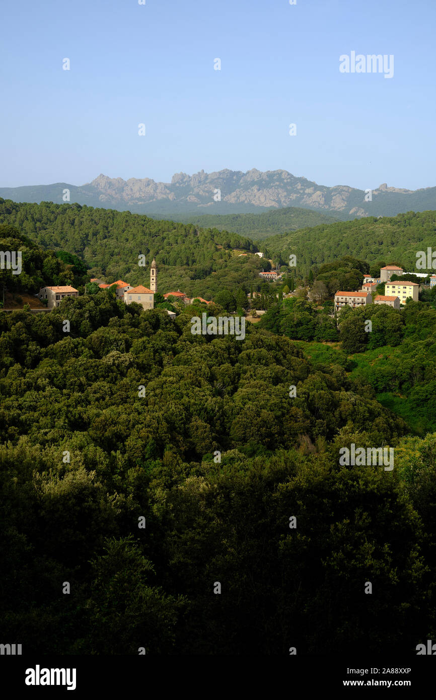 The green mountain interior landscape and village of Levie with the Aiguilles de Bavella in the distance, Alta Rocca, Corse-du-Sud Corsica France Stock Photo