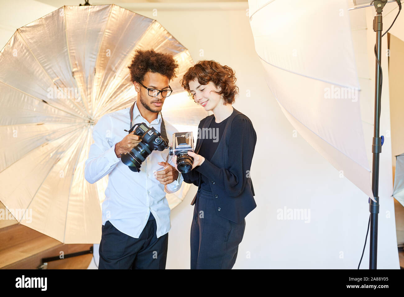 Photographers with digital and retro medium format camera in the photo studio Stock Photo