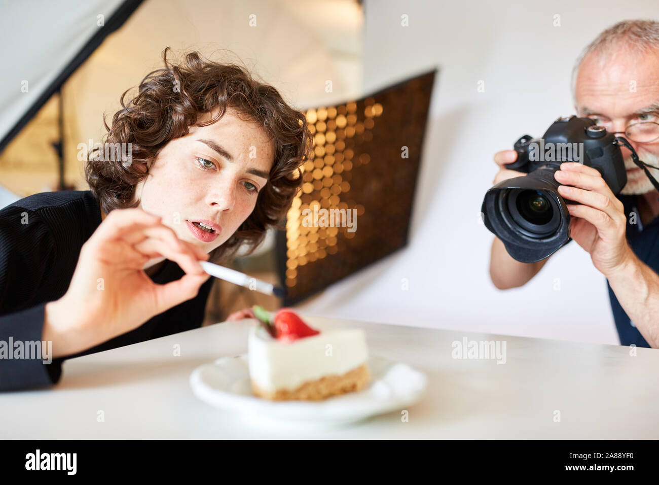 Food stylist and photographer with camera taking photos of food Stock Photo
