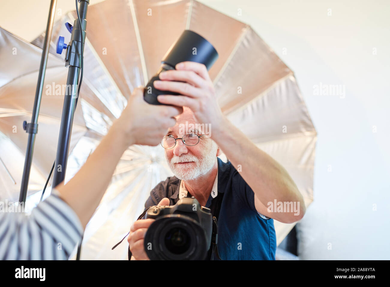 Professional photographer gets help with lens change to camera Stock