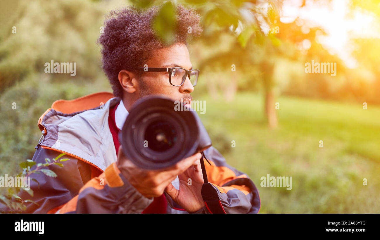 Paparrazi photographer secretly photographs for spying photos in nature Stock Photo