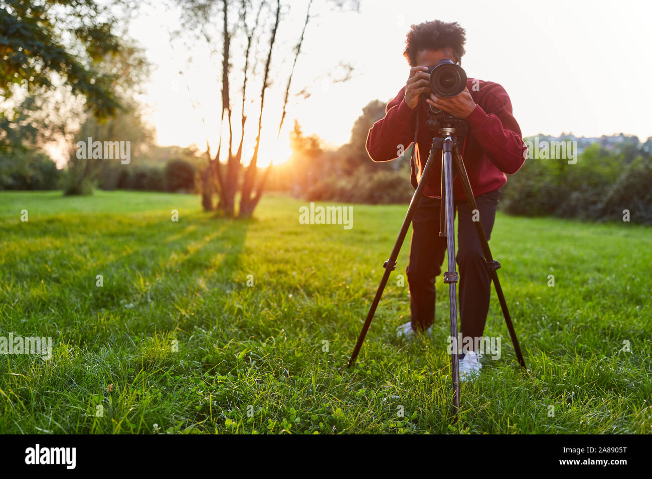 Photographer on a meadow as a landscape photographer with camera on the ...