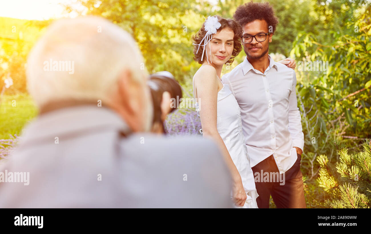 Photographer photographing a wedding with bride and groom in nature Stock Photo