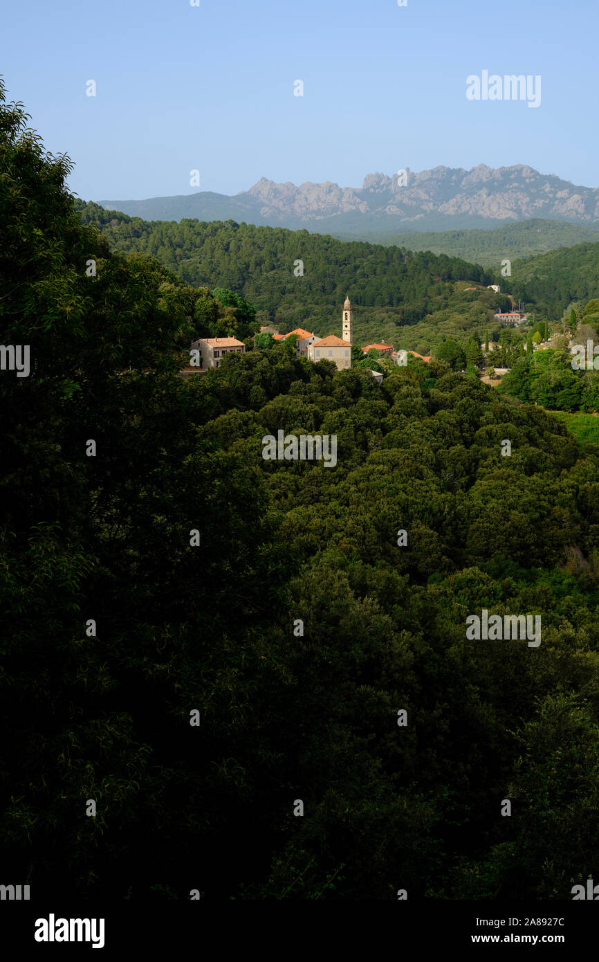 The green mountain interior landscape and village of Levie with the Aiguilles de Bavella in the distance, Alta Rocca, Corse-du-Sud Corsica France Stock Photo