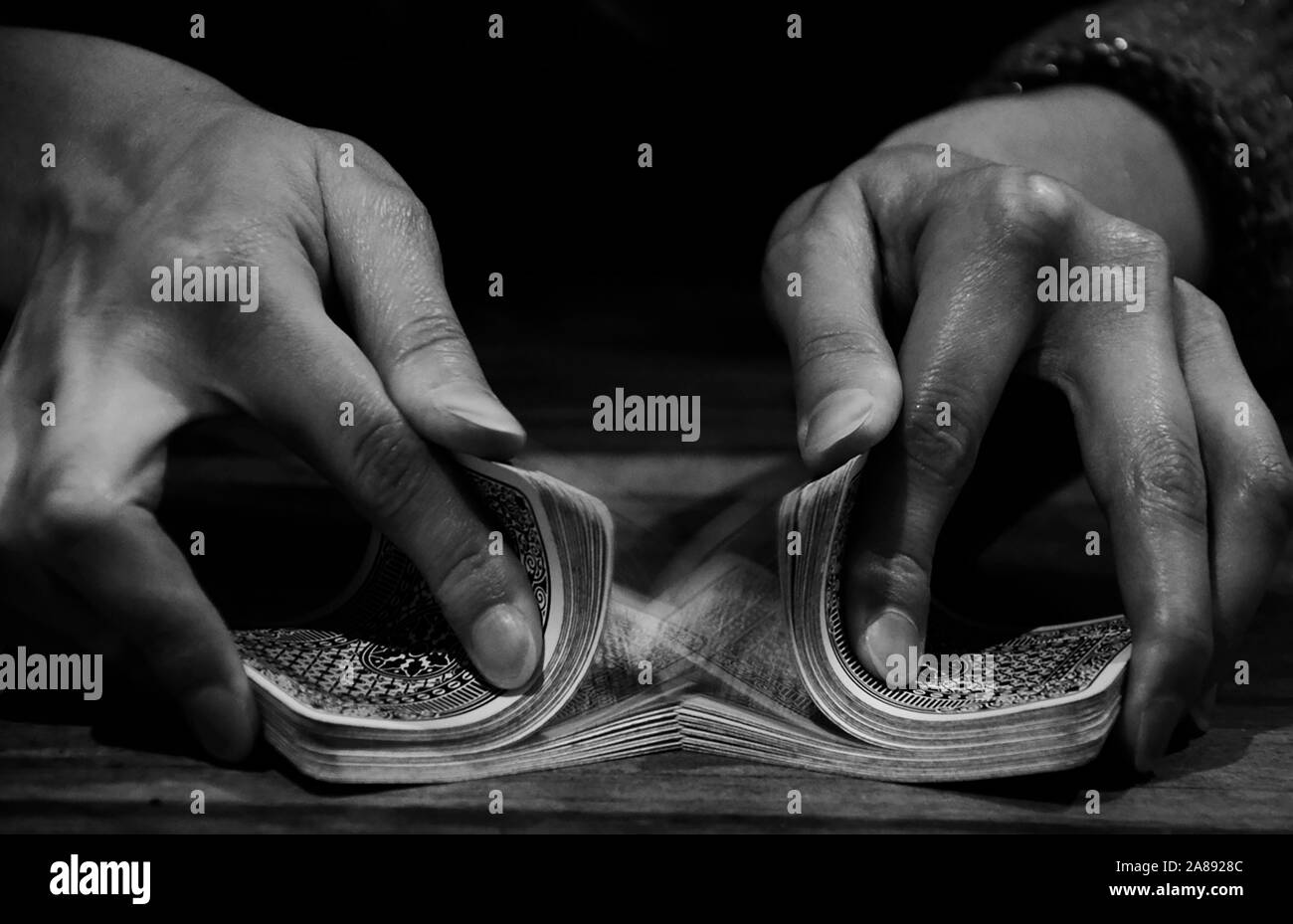 Shuffling hands - black and white image of a riffle shuffle Stock Photo -  Alamy